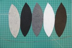 four pieces of felt are laid out on a cutting board to be sewn together