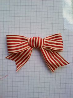 a red and white striped bow sitting on top of a piece of paper