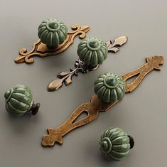 an assortment of decorative knobs and pulls on a gray surface with gold trimming