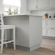 a white kitchen with an island and bar stools