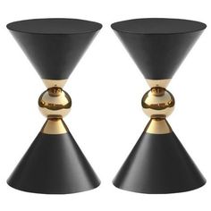 two black and gold candlesticks sitting next to each other on a white background