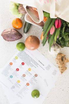 an assortment of fruits and vegetables sitting on top of a white countertop next to a bag