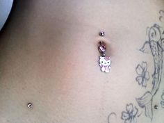 a hello kitty belly button with a pink bow on it's side and an earring in the middle