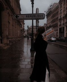 a woman is walking down the street with an umbrella