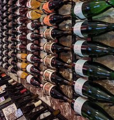 many bottles of wine are lined up on the wall