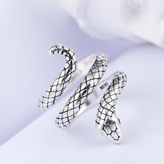 Be fierce and fashionable at the same time by wearing this Adjustable Ring by Innovato Design. The look on the snake's countenance will give you a reason to be bold on putting on extraordinary outfits. Made of 925 sterling silver, this amazing ring has a shiny surface that will highlight your hand and give that stylish appearance. It is in the form of a coiled snake with dominant marks of scales and crystal gypsy-set red round brilliant cut stone eyes. You can wear this ring when you work at the office, attend a party, or go on other occasions. Also, you can give this as a gift to your loved ones on their birthday, on Valentine's, Christmas, and New Year.  Product Highlights:   Made of 925 sterling silver  Resizable  Perfect for office wear  Versatile, durable, and soft enough to be engrav Ladies Finger Ring, Snake Ring Silver, Snake Jewelry, Animal Rings, Party Rings, Snake Ring, Finger Rings, Original Jewelry, Grunge Style