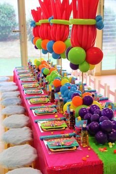 the table is set up with balloons and streamers