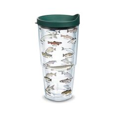 a glass cup with fish on it and a green lid sits in front of a white background