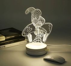 a lamp that is sitting on top of a table next to a mouse and books