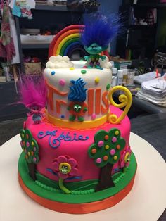 a birthday cake decorated with monsters and rainbows