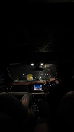 the interior of a car at night with its lights on and people sitting in it