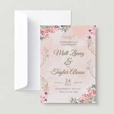 a wedding card with pink flowers and gold foil on the front, next to an envelope