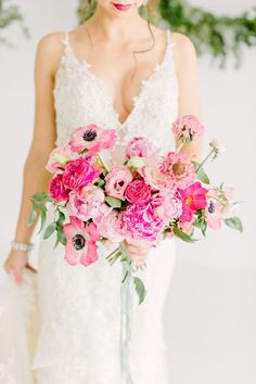 a bride holding a bouquet of pink flowers