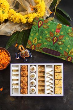 an assortment of food items displayed on a table with yellow flowers in the back ground