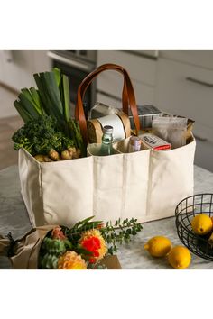 a white bag filled with groceries sitting on top of a counter next to lemons