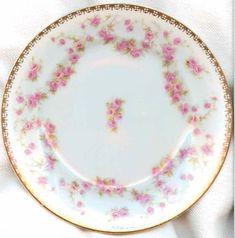 an antique china plate with pink flowers on it