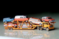 three toy cars are being transported on a tow truck