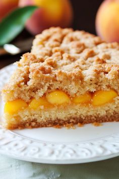 a close up of a piece of cake on a plate with peaches in the background