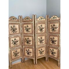 a room divider made out of wood and painted with floral designs on the doors