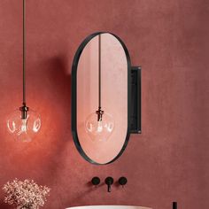 a bathroom with a sink, mirror and two lights on the wall next to it