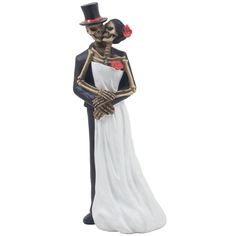 a figurine of a skeleton dressed in a white dress and black top hat