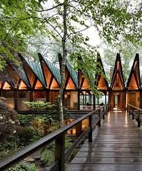 a wooden walkway leading to several cabins in the woods