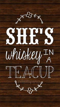 the words she's whiskey in a teacup on a wooden background with white lettering