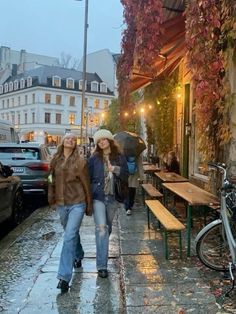 two women walking down the street in the rain