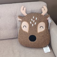 a stuffed deer pillow sitting on top of a couch