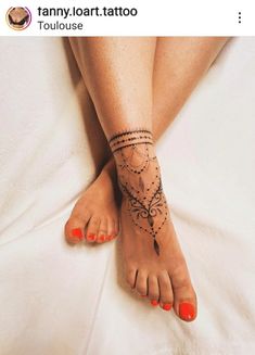 a woman's foot with tattoos on it and an orange nail polish vare