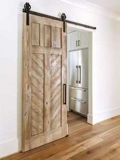 an open wooden door in the middle of a room with white walls and wood floors