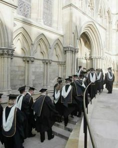 a group of men in graduation gowns standing on steps