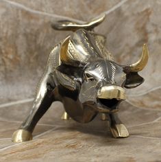 a brass bull figurine sitting on top of a tile floor next to a wall