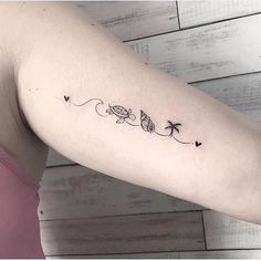 a woman's arm with an arrow and palm trees tattoo on the left inner arm