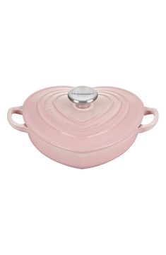 a pink casserole dish with two handles and an oval handle on the side