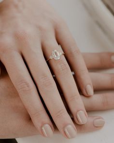 a woman's hand with a diamond ring on it