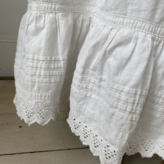 This gorgeous textile is French and dates from the late 1800's or very early 1900's . White, crisp cotton with lace detail. I love wearing these with boots! ~ GORGEOUS! Ideal for wearing, display or design inspiration ( E 127 ) MEASUREMENTS : This gorgeous Vintage French skirt measures : 33 inches long 28 inch approx. CONDITION : I've freshly laundered and pressed this gorgeous textile. There are rust stains on the clasp area ( please see photographs) and the body has some tiny tiny rust stains White Regency Style Petticoat With Ruffles, Victorian White Ruffled Petticoat, Victorian White Petticoat With Ruffles, White Regency Style Cotton Petticoat, White Broderie Anglaise Cotton Skirt, Victorian Ruffled Skirt, White Cotton Skirt With Broderie Anglaise, Vintage White Lace Bottoms, White Vintage Lace Bottoms