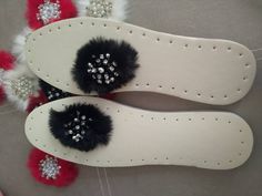 two pairs of white shoes with black and red fur