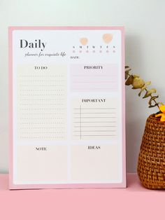 the daily planner is next to a basket with flowers