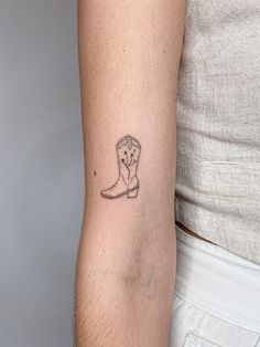 a woman's arm with a tattoo of a cowboy boot and a clock on it