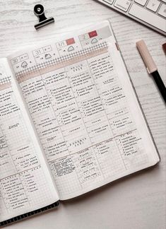 an open planner sitting on top of a desk next to a keyboard