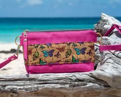 a pink purse sitting on top of a tree stump next to the ocean with text reading make this cross - body wristlet purse free sewing pattern