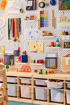 a child's playroom with toys and crafting supplies on the wall behind it