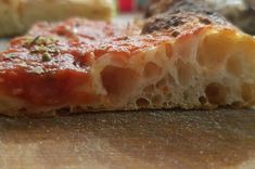 a piece of pizza sitting on top of a cutting board next to other food items