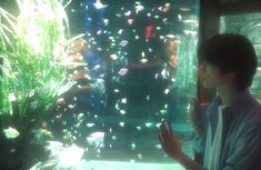 a man standing in front of a fish tank