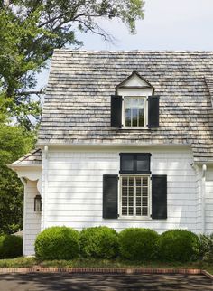 a white house with black shutters on the windows