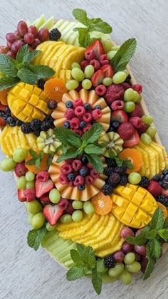 an arrangement of fruit is arranged in the shape of a pyramid on a white surface