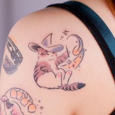 a woman's arm with tattoos on it and an image of a cat reading a book