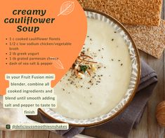 a bowl of creamy cauliflower soup on a table with bread and nuts