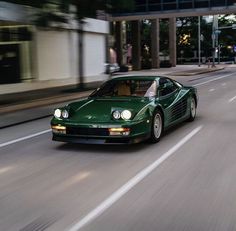 a green sports car driving down the street